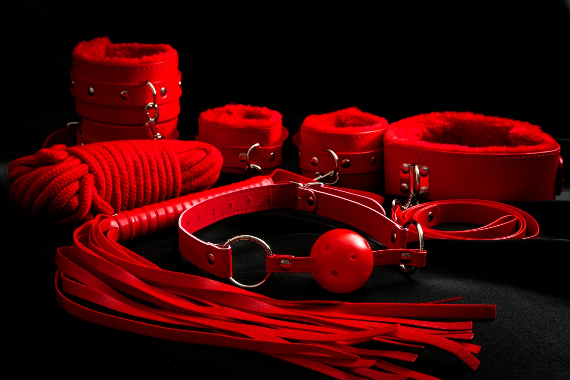 Red bondage kit set on black background with dramatic light
